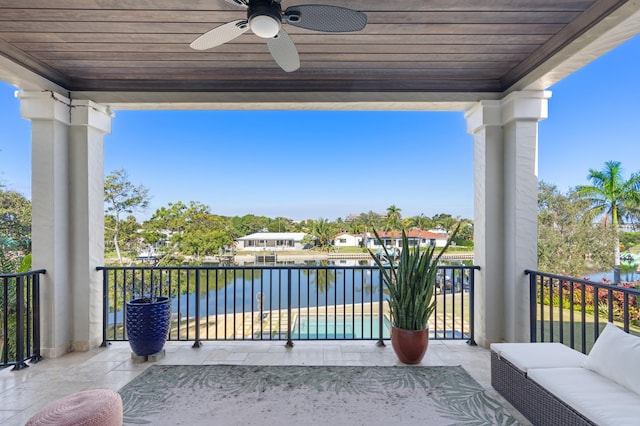 balcony with ceiling fan and a water view