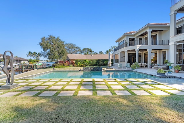 view of swimming pool featuring a jacuzzi, a patio area, and a lawn