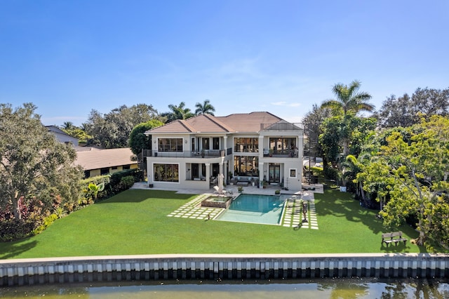 rear view of property with a balcony, a patio, an outdoor living space, a water view, and a yard