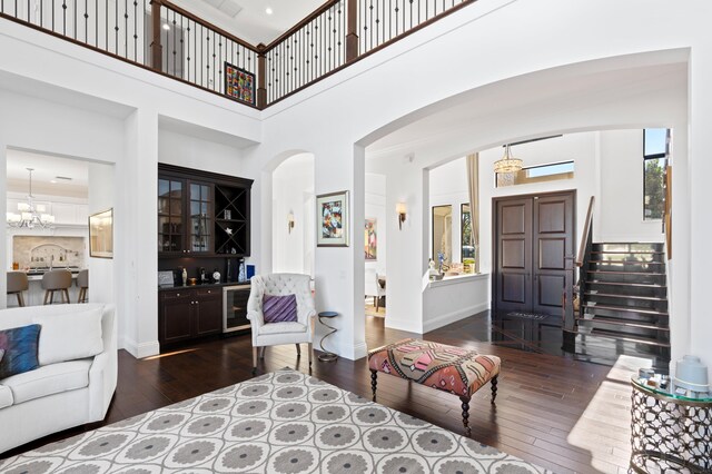 living room featuring a high ceiling, plenty of natural light, and dark wood-type flooring