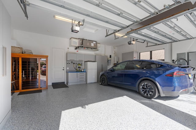 garage featuring white refrigerator, a garage door opener, and water heater