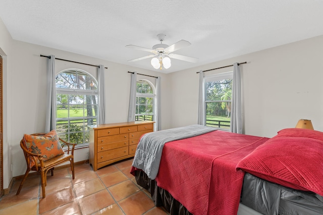 tiled bedroom with a textured ceiling and ceiling fan