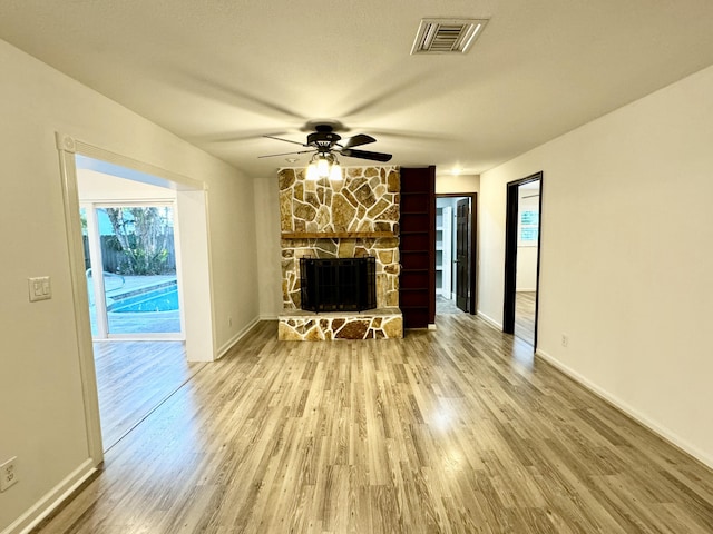 unfurnished living room with a fireplace, hardwood / wood-style floors, and ceiling fan