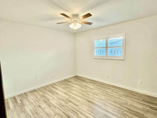 empty room with ceiling fan, light hardwood / wood-style floors, and a textured ceiling