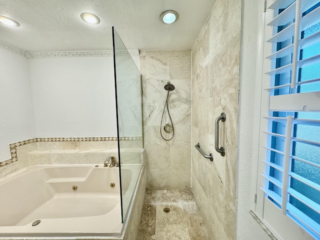 bathroom featuring shower with separate bathtub and a textured ceiling