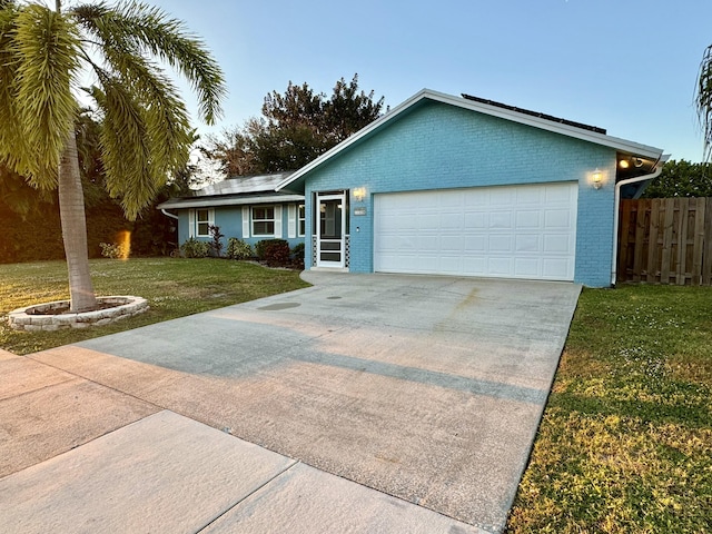 ranch-style home with a front lawn and a garage