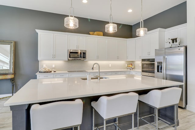 kitchen featuring sink, a center island with sink, and appliances with stainless steel finishes