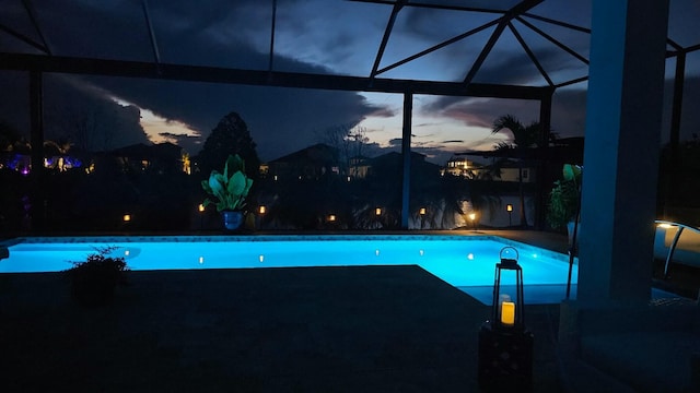 pool at dusk with a lanai