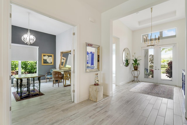 entrance foyer with an inviting chandelier, light hardwood / wood-style floors, and a wealth of natural light