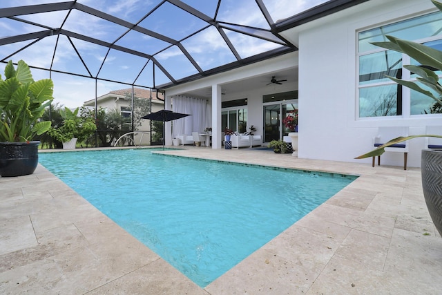 view of swimming pool featuring a patio, ceiling fan, and glass enclosure