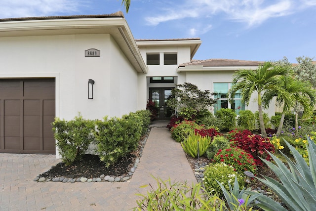 entrance to property featuring a garage and french doors