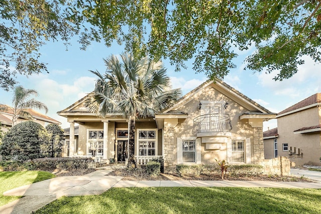 view of front of home with a balcony and a front lawn