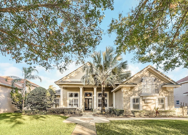 view of front of property featuring a front yard and a balcony