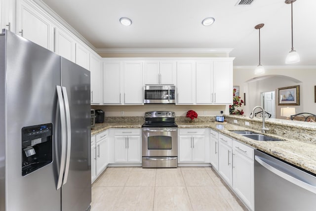 kitchen featuring light stone counters, pendant lighting, stainless steel appliances, white cabinetry, and a sink