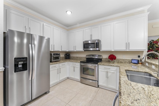 kitchen with light stone counters, light tile patterned floors, appliances with stainless steel finishes, white cabinetry, and a sink