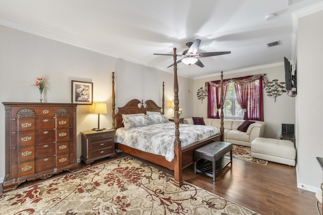 bedroom featuring dark wood-style floors, crown molding, visible vents, ceiling fan, and baseboards