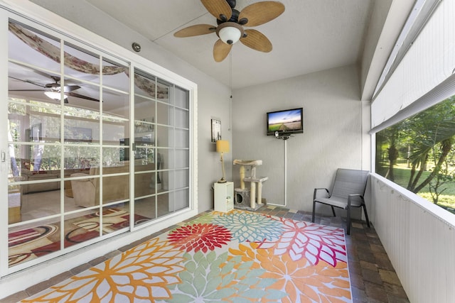 sunroom / solarium featuring ceiling fan