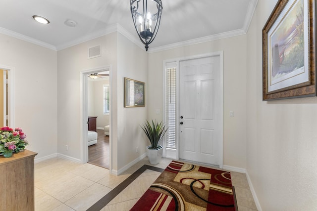 foyer featuring baseboards, visible vents, crown molding, and light tile patterned flooring