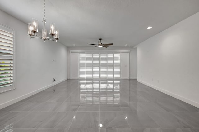 unfurnished room with a textured ceiling and ceiling fan with notable chandelier