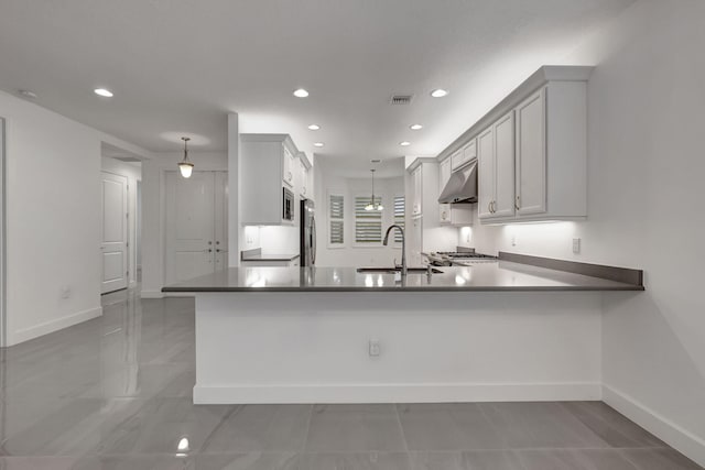 kitchen featuring kitchen peninsula, sink, hanging light fixtures, and appliances with stainless steel finishes