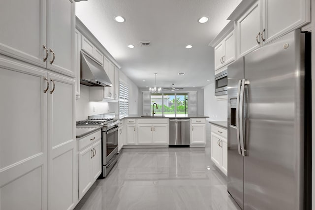 kitchen with ceiling fan, sink, stainless steel appliances, kitchen peninsula, and white cabinets