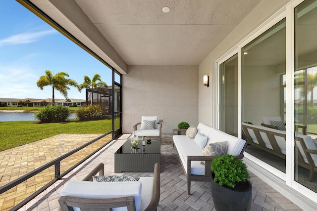 balcony featuring an outdoor living space, a water view, and a patio area