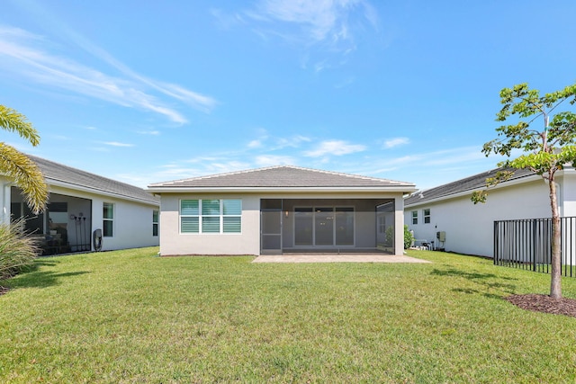 back of property featuring a sunroom and a yard