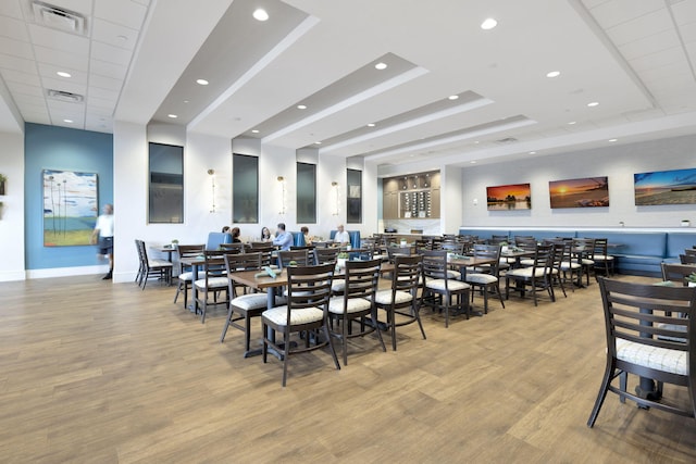 dining area featuring light hardwood / wood-style floors and a raised ceiling