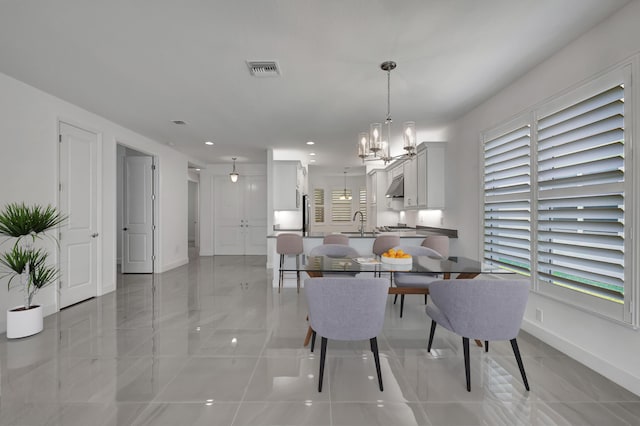 dining area featuring a chandelier and sink