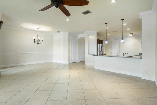 unfurnished living room with ornamental molding, sink, ceiling fan with notable chandelier, and light tile patterned floors