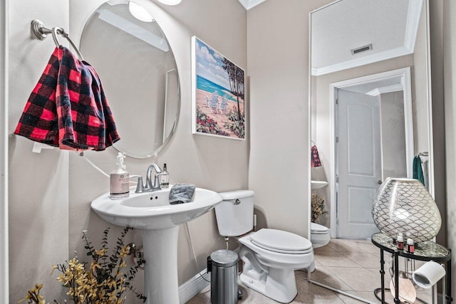 bathroom featuring tile patterned flooring, ornamental molding, and toilet