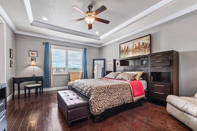 bedroom featuring a raised ceiling, crown molding, dark hardwood / wood-style flooring, and ceiling fan