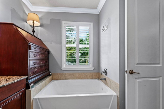 bathroom with a bathing tub, ornamental molding, and vanity