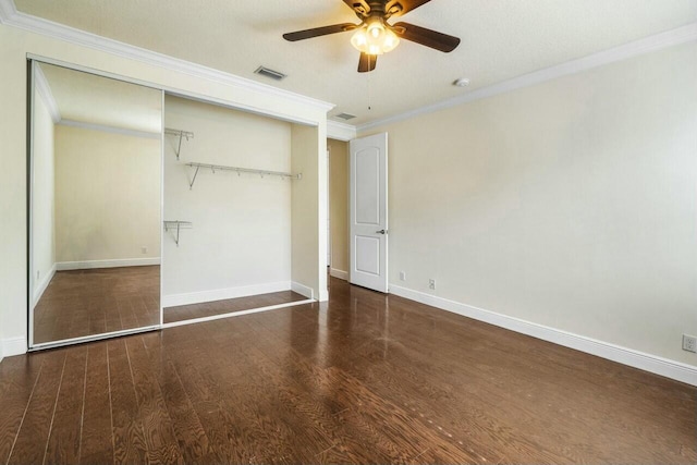 unfurnished bedroom with crown molding, ceiling fan, dark hardwood / wood-style flooring, and a closet