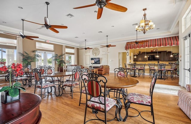 dining space featuring a notable chandelier, light hardwood / wood-style flooring, ornamental molding, and french doors