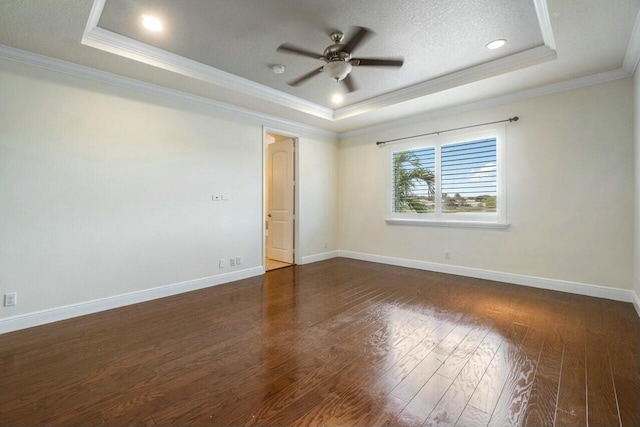 unfurnished room with dark wood-type flooring, ornamental molding, a raised ceiling, and ceiling fan