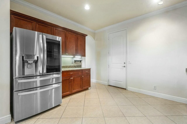 kitchen featuring stainless steel refrigerator with ice dispenser, ornamental molding, light stone counters, and light tile patterned floors