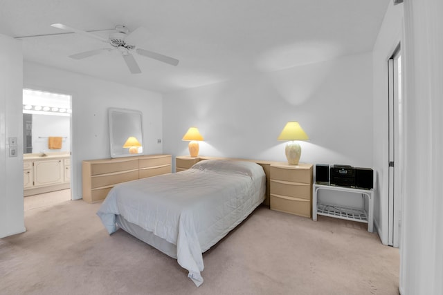 bedroom featuring connected bathroom, light colored carpet, and ceiling fan