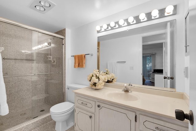 bathroom featuring vanity, toilet, and a shower with shower door