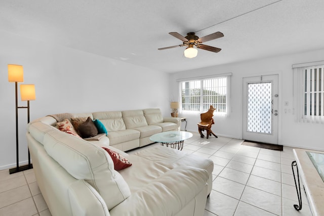 living room featuring light tile patterned floors, a textured ceiling, and ceiling fan