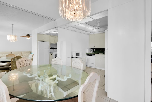 tiled dining area with ceiling fan with notable chandelier