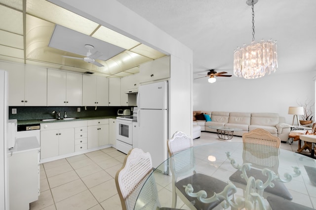 kitchen with backsplash, white appliances, ceiling fan with notable chandelier, decorative light fixtures, and white cabinets