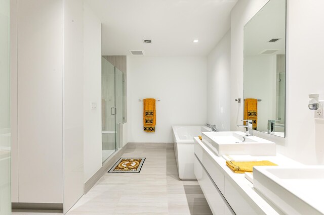 bathroom with tile patterned floors, vanity, and plus walk in shower