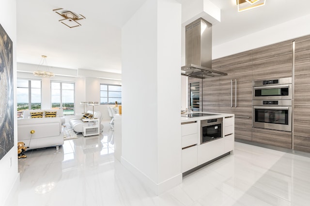 kitchen with double oven, black electric cooktop, exhaust hood, and decorative light fixtures