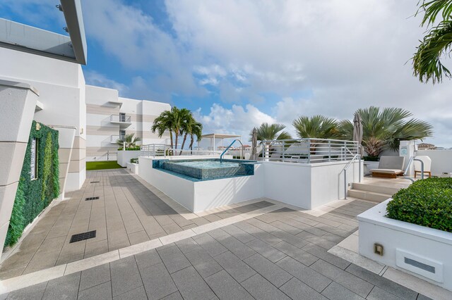 view of pool featuring a patio area and an in ground hot tub