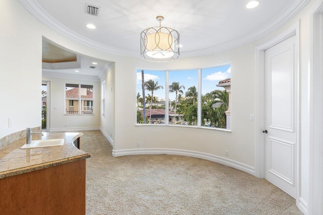 unfurnished dining area with light carpet, ornamental molding, and sink