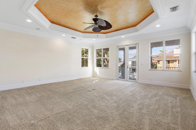 carpeted empty room with french doors, a raised ceiling, ceiling fan, and crown molding