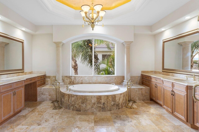 bathroom with vanity, a chandelier, a tray ceiling, and decorative columns