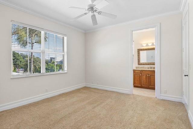 unfurnished bedroom featuring ensuite bathroom, ceiling fan, light colored carpet, and ornamental molding