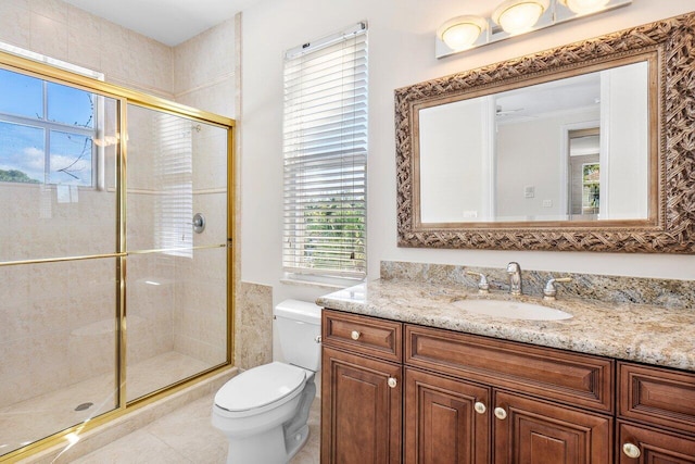 bathroom featuring tile patterned floors, vanity, toilet, and walk in shower